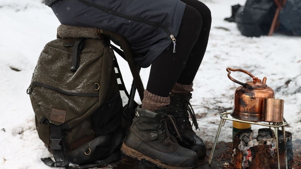 Person som sitter på en stolryggsäck i vintrigt landskap