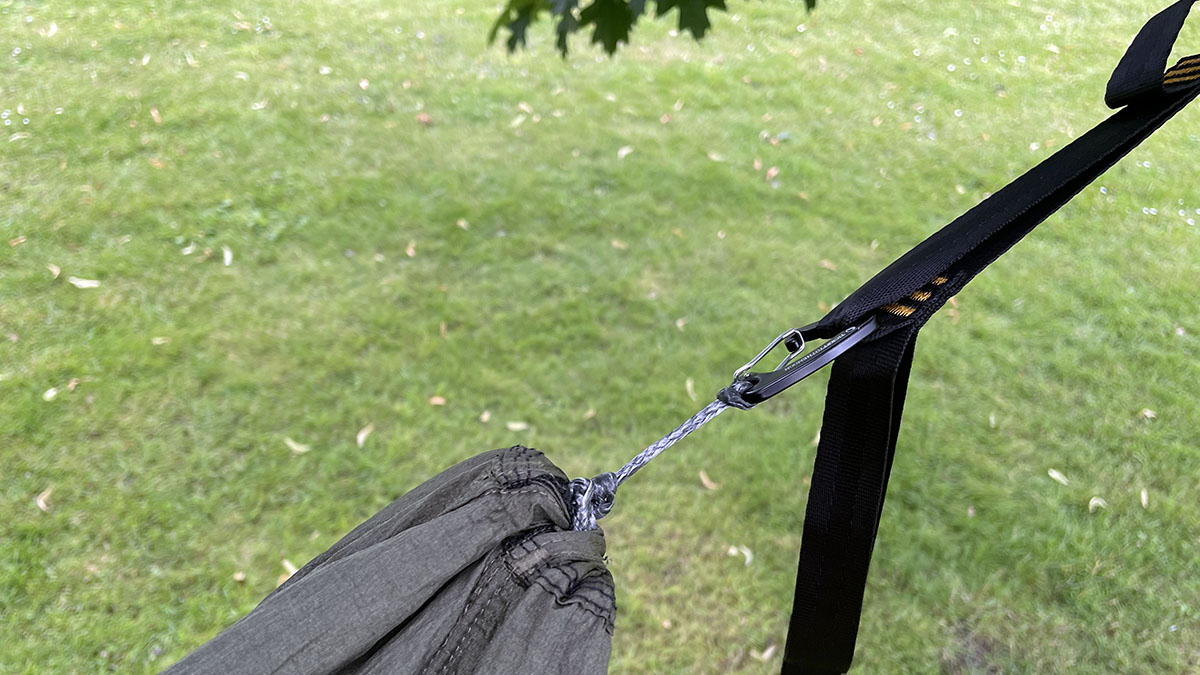 Hängmattan fästs ibland med upphängningsrem och karbinhake.