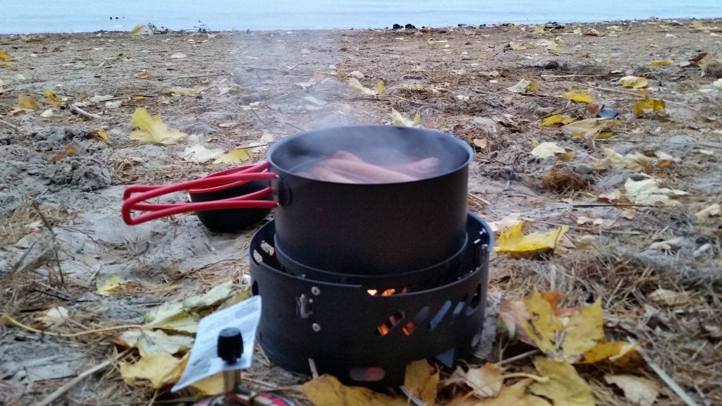 Gasolkök som kokar korv i höstmiljö med vatten i horisonten
